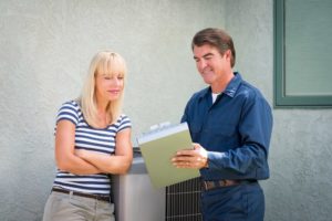 Hvac Tech And Client Looking At Clipboard