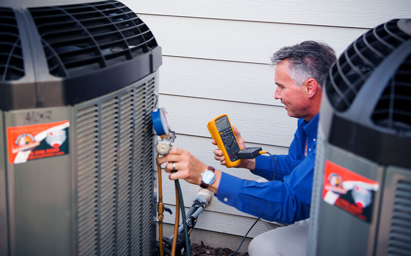 Service tech working on air conditioner diagnosis